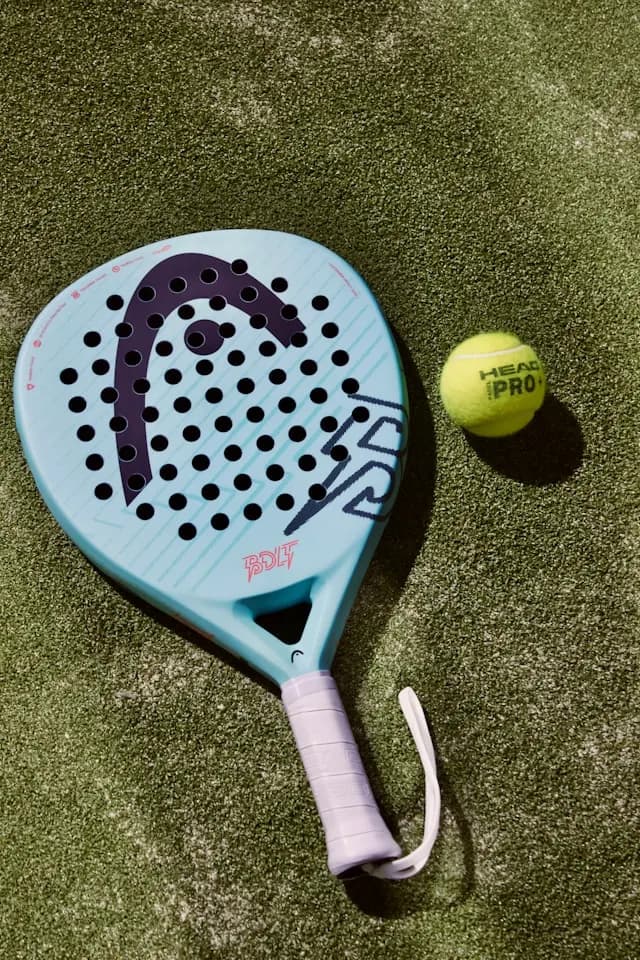 A padel racket and ball on a padel court
